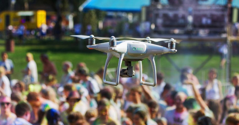 Equipamento sobrevoa e monitora uma área industrial, destacando o uso de drones na segurança.