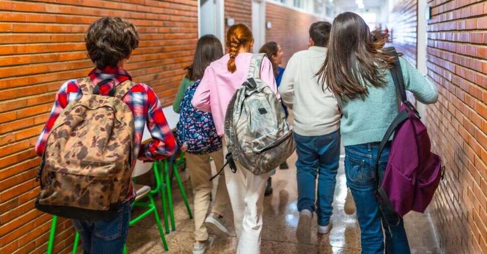 Alunos dirigem-se à saída do corredor em guia sobre evacuação emergencial nas escolas.